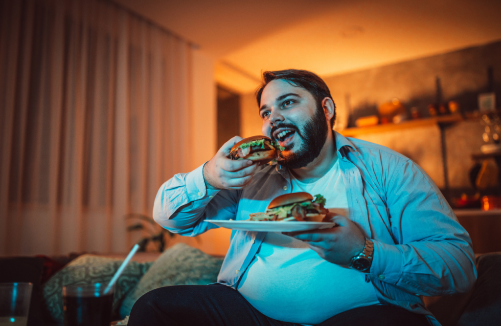 Man watching a movie while binge eating. Hypnotherapy. Brisbane Livewell Clinic