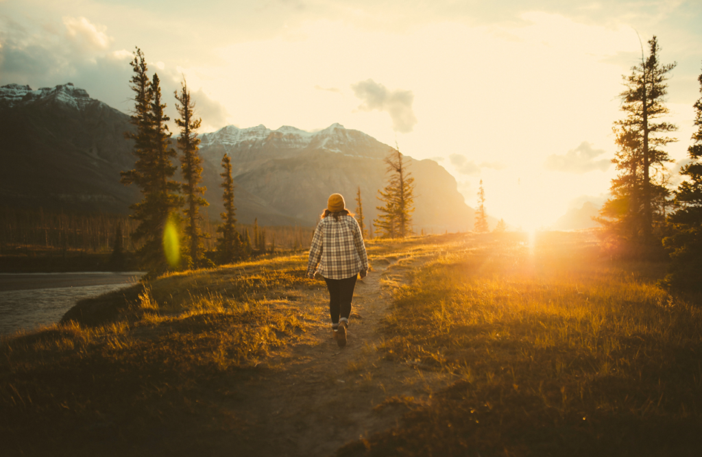 Woman walking on a field during sunset. Hypnotherapy. Brisbane Livewell Clinic