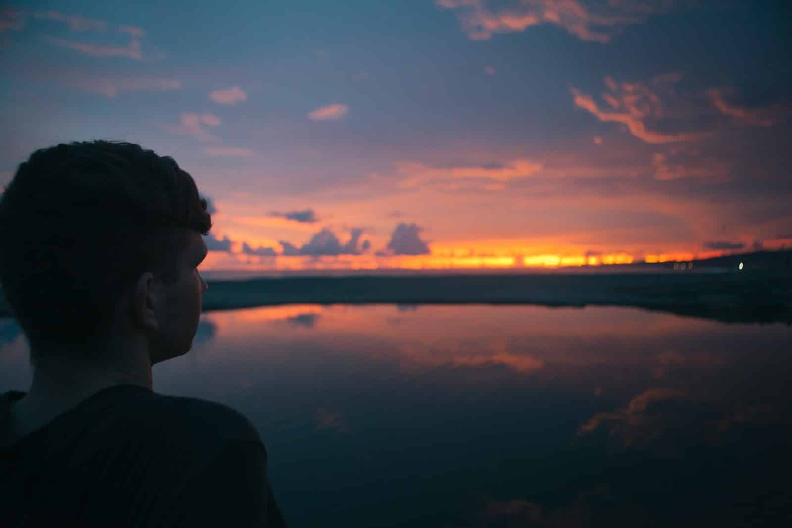 person standing near sea under cloudy sky. Psychosomatic Therapy Brisbane