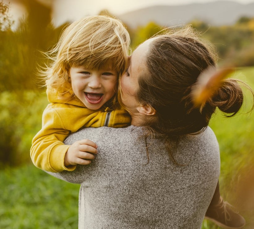 Woman hugging a laughing child. Brisbane Livewell Clinic. Naturopath, Wellness Clinic, Natural Therapies and Allied Health