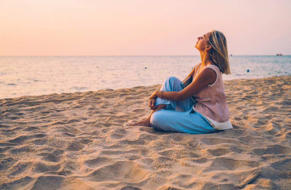 Woman sitting on the seashore. Hypnotherapy services. Brisbane Livewell Clinic