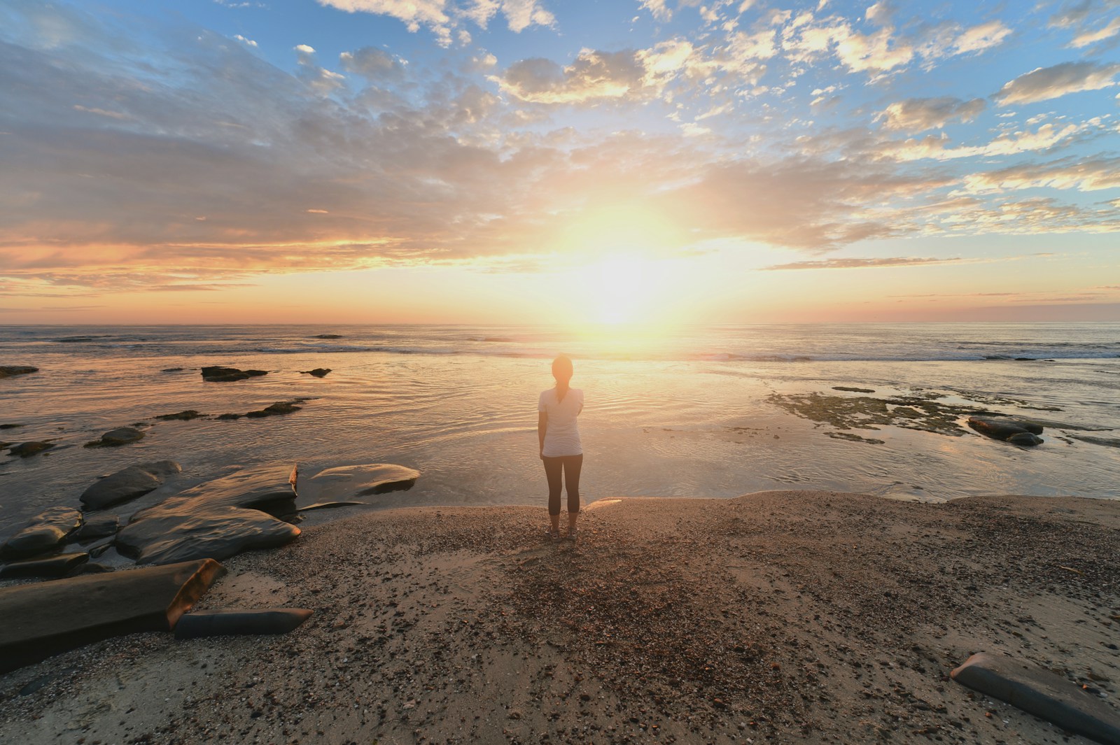 Man standing on beach at sunrise. Mindset therapy in Australia