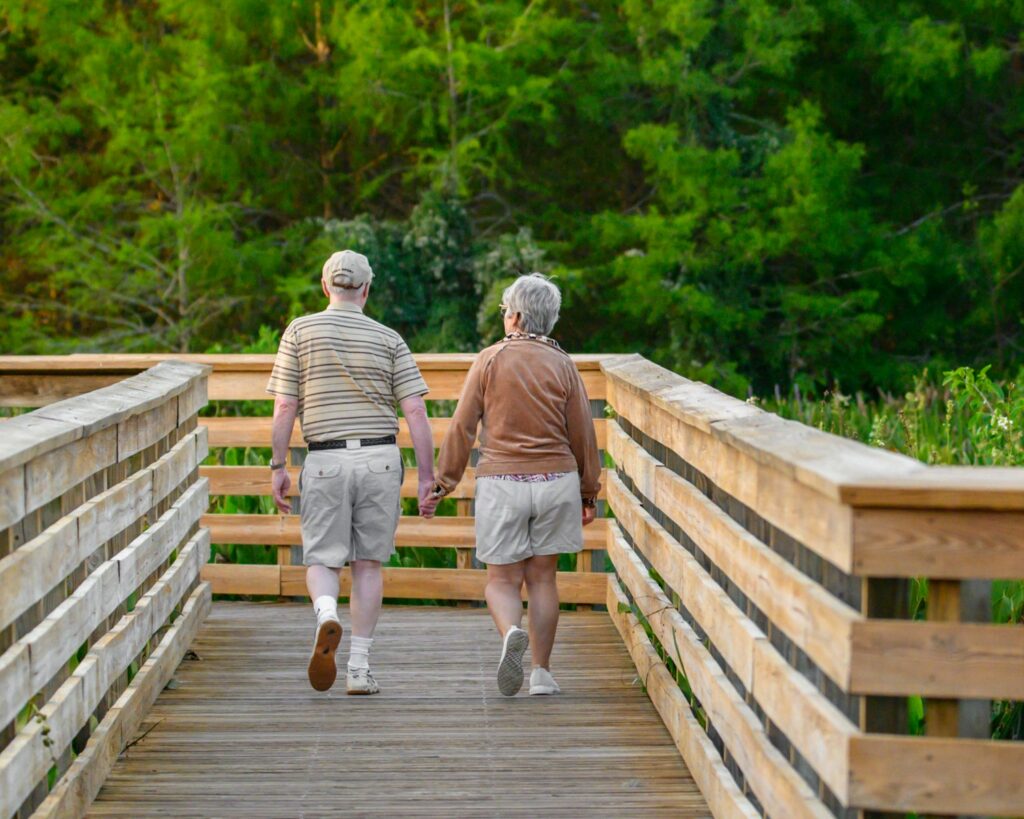 Older couple walking across a bridge. Naturopath near me