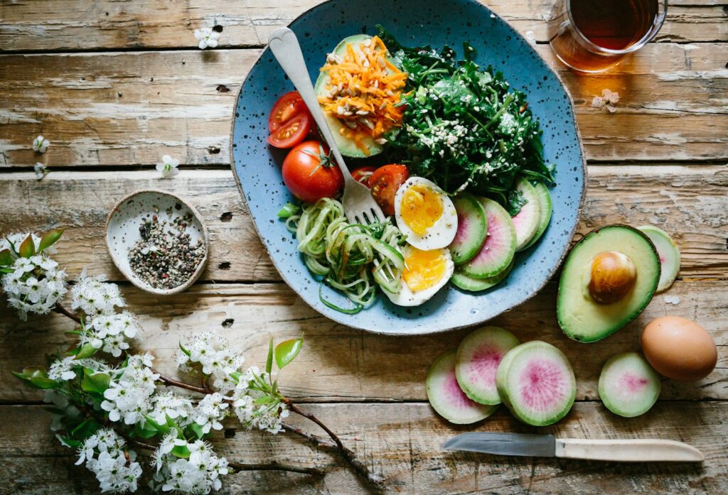 Poached egg with vegetables and tomatoes on blue plate. Dietitian Australia