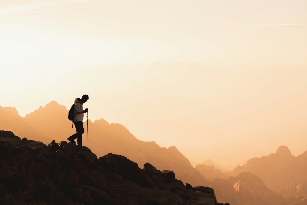 Man hiking down a mountain after therapy by skilled Bowen professionals