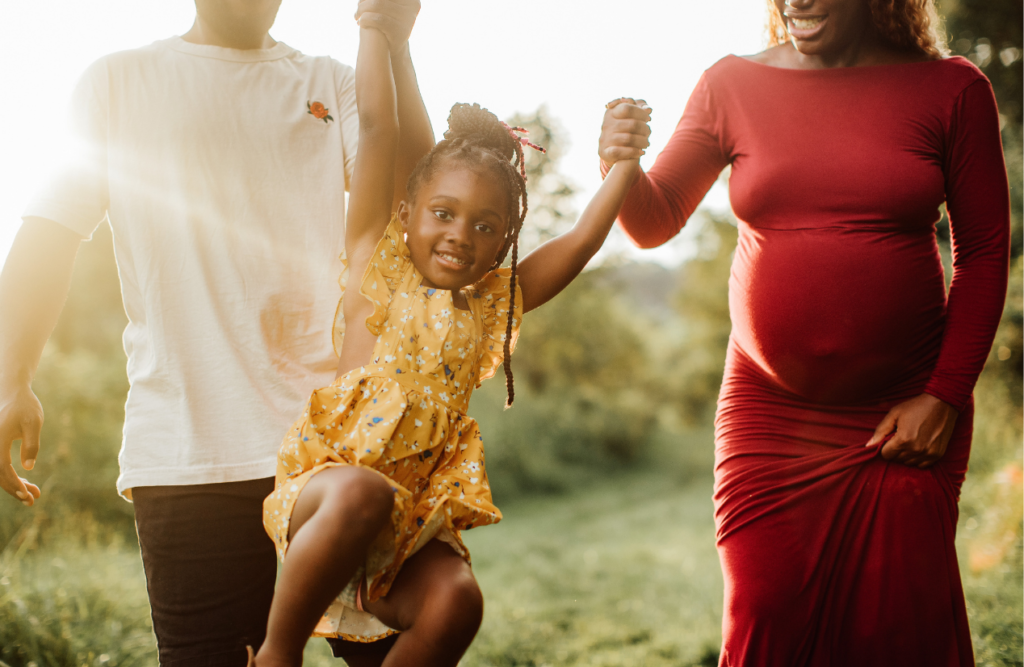 Pregnant mother, father and daughter swinging between them. Methylation Test. Brisbane Livewell Clinic