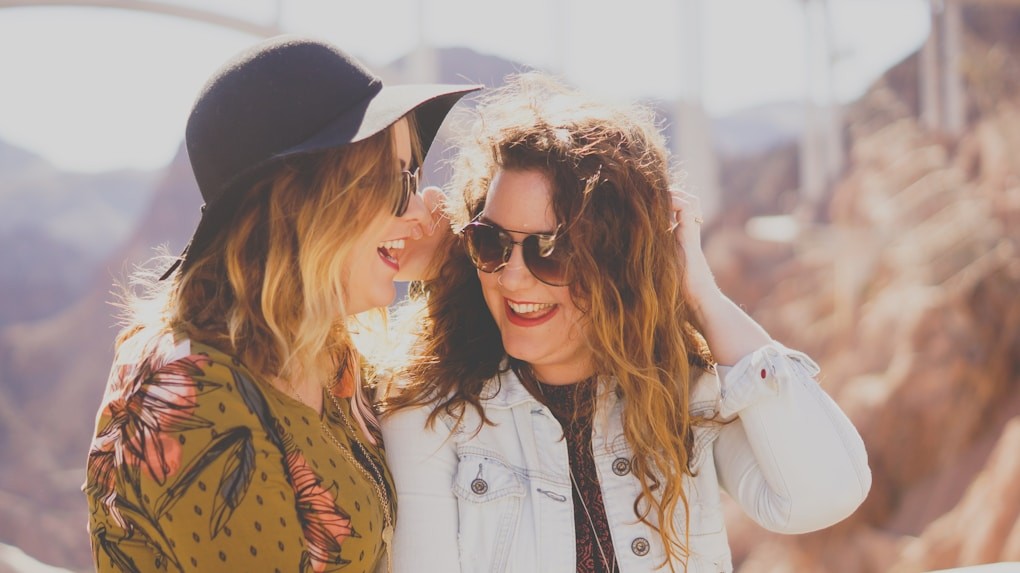 Two women smiling while rock climbing. Mindset Therapy