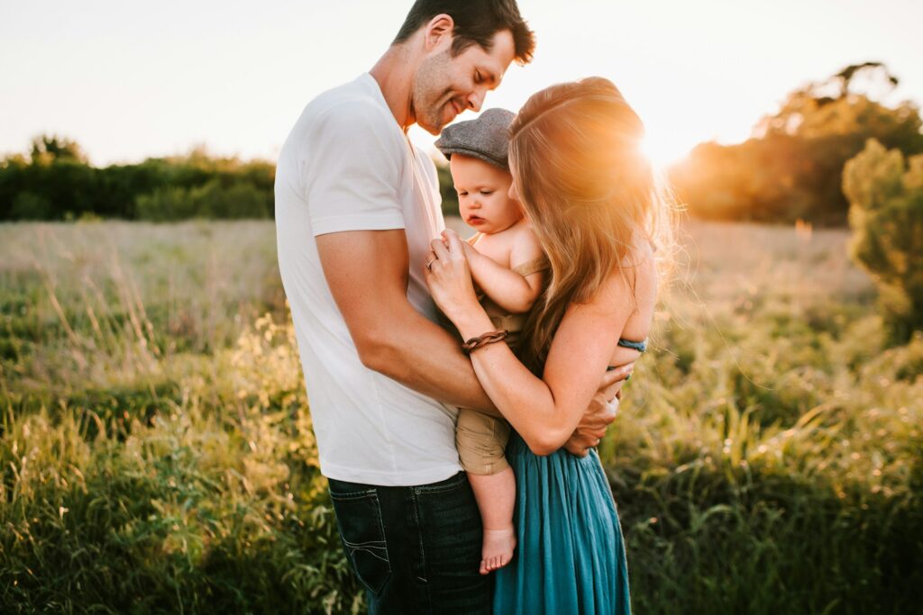 Family hugging in a meadow after therapy by skilled Bowen professionals