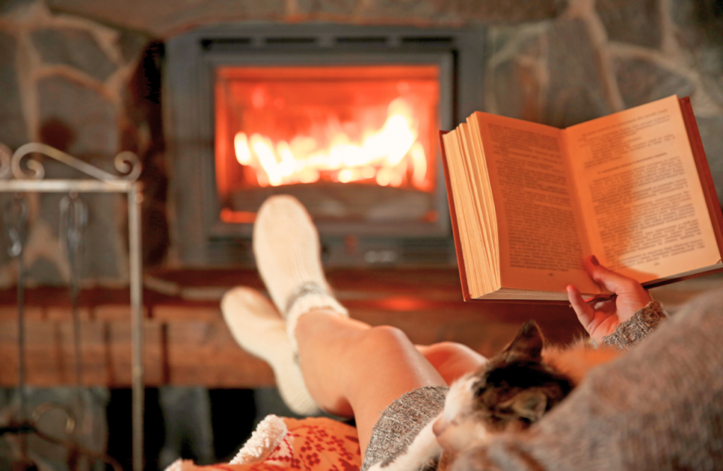 Woman reading book near fireplace. Swedish Massage Brisbane. Brisbane Livewell Clinic