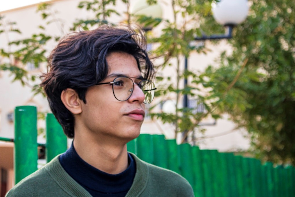 Boy in green crew neck shirt wearing black framed glasses. Youth Counselling Brisbane