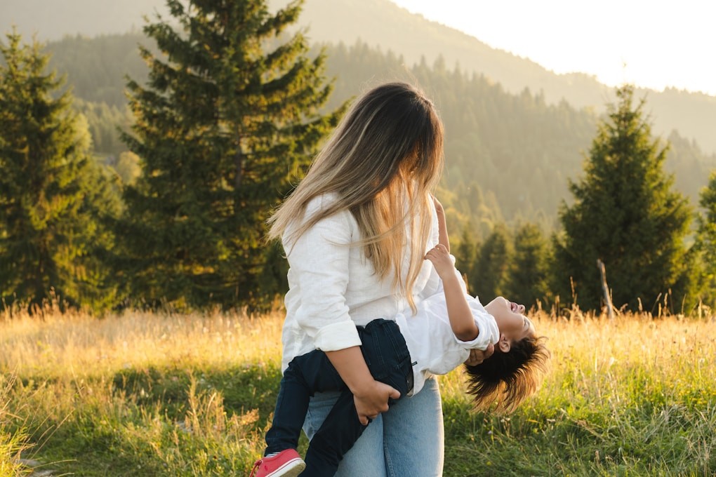 A woman holding a child in a field. Naturopathy. Why see a Naturopath