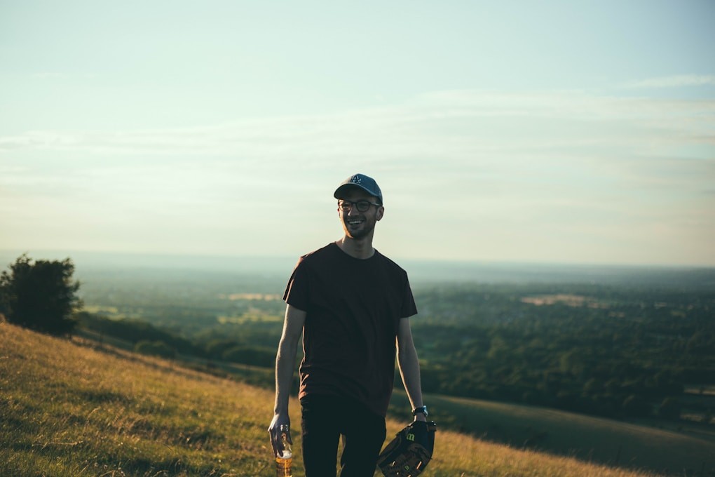 Man standing on a mountain smiling after Mindset Therapy.