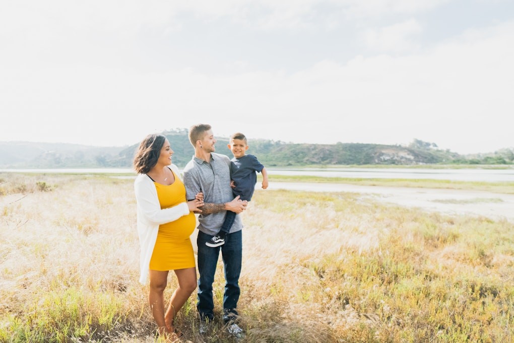 Family standing on a grassy field. Why see a Naturopath?