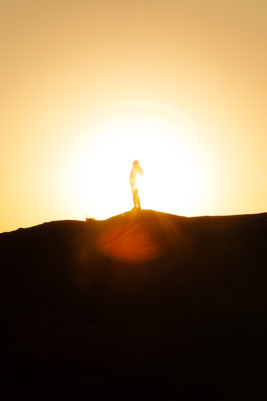 A person standing on top of a hill at sunset. Nicky Jackson / Nicole Jackson