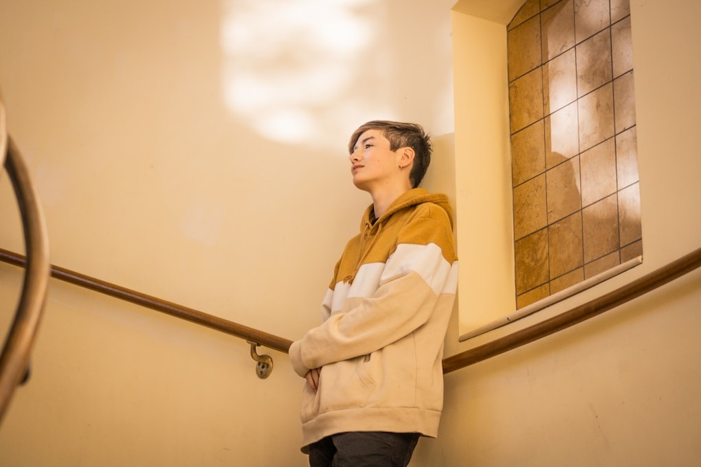 Teenage youth standing on the stairs of a building. Youth Counselling Brisbane