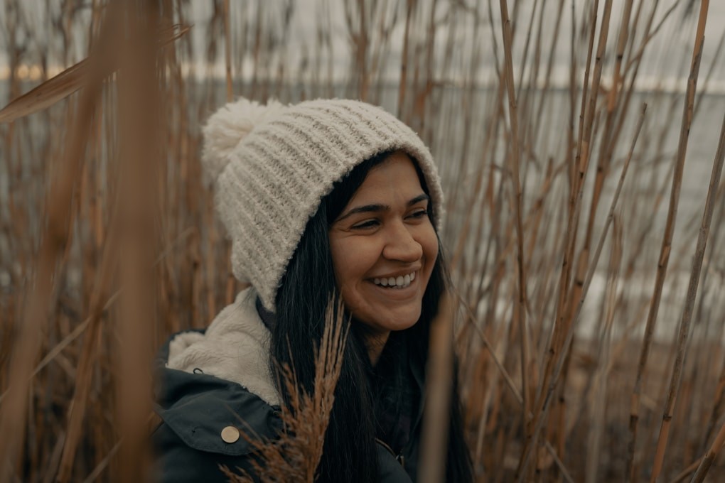 Woman in white knit cap and black jacket smiling after Mindset Therapy