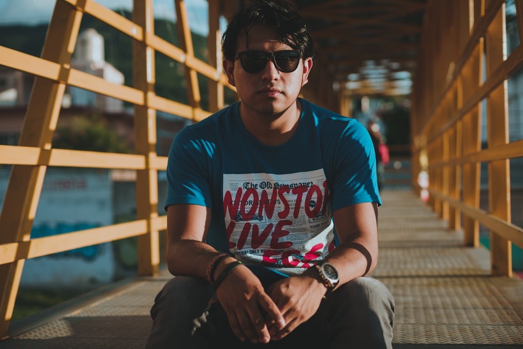 Youth sitting on a wooden walkway wearing sunglasses. Youth Counselling Brisbane