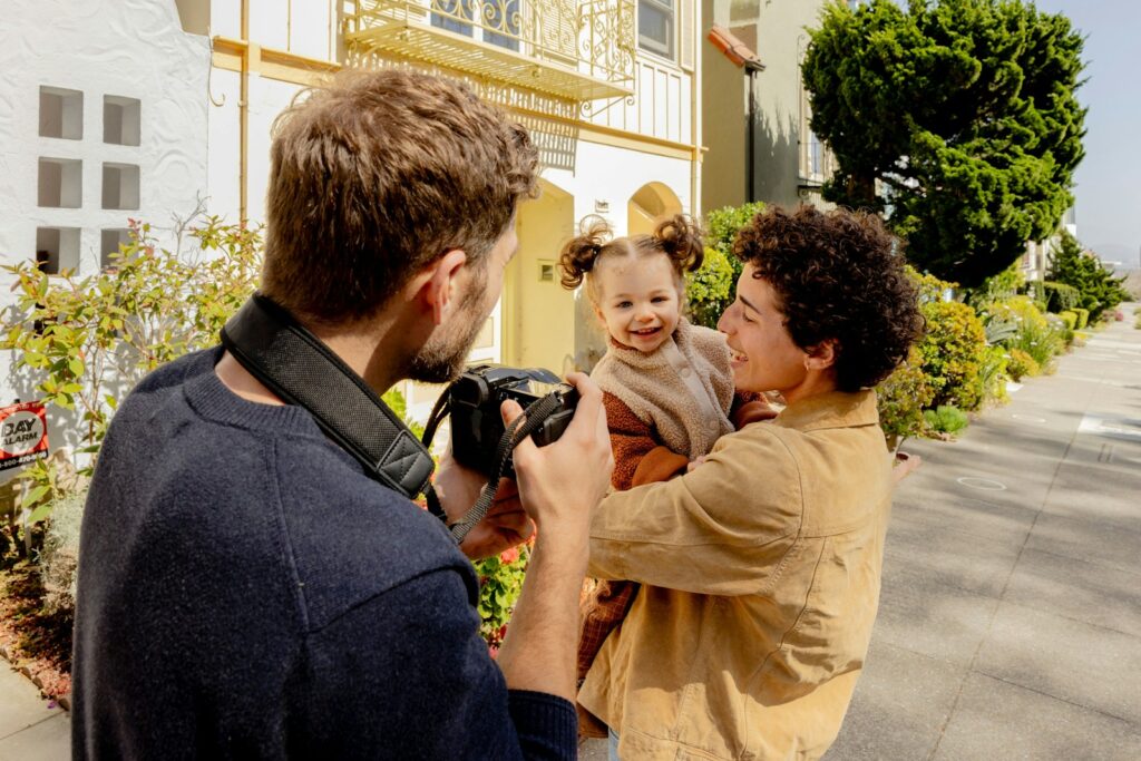 A man taking a picture of a woman holding a baby. Skilled Bowen professionals