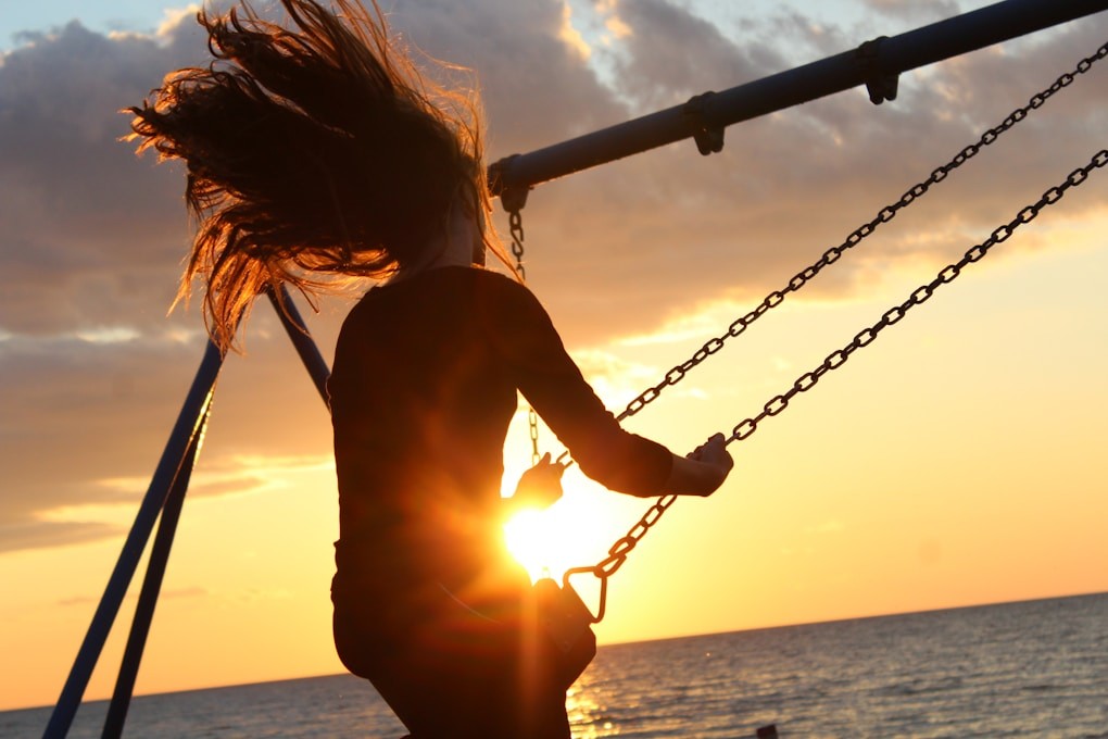 Woman swinging on a swing during sunset. Weight Loss Hypnosis Brisbane. Naturopath Brisbane Northside