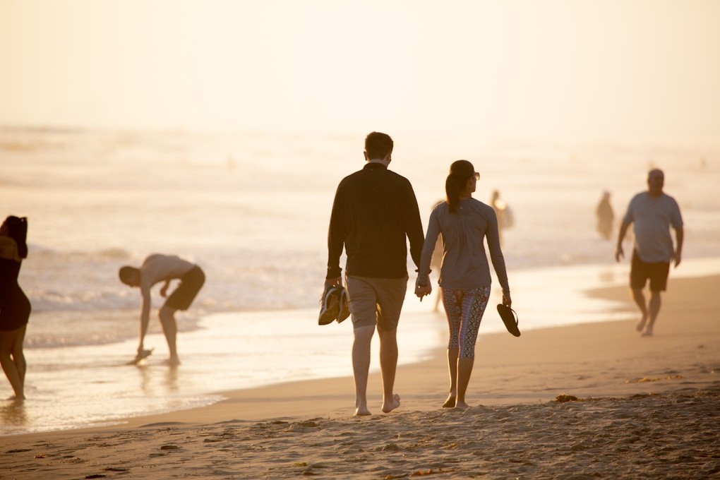 Man and woman holding hands while walking on beach after seeing their Naturopath Caloundra, Shella Hall. Counselling Clayfield