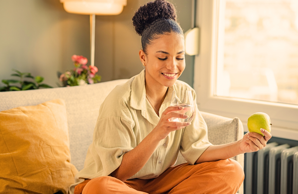 Woman maintaining healthy habits by drinking water and eating an apple. Power of Hypnosis. Brisbane Livewell Clinic