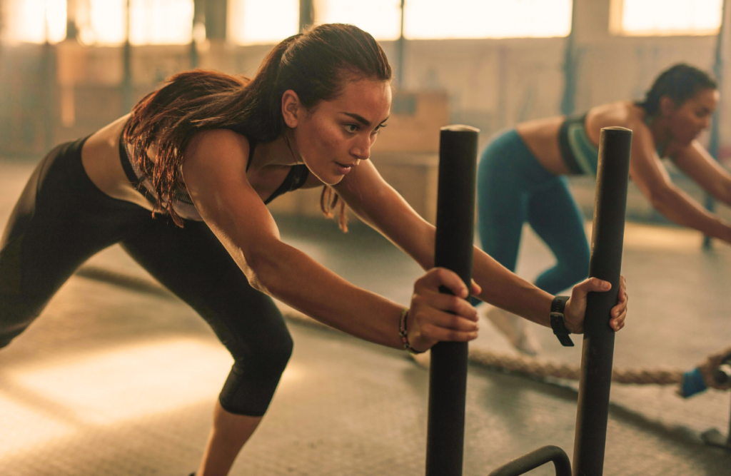 Two women pushing the prowler exercise equiptment at the gym. Hypnosis sleep. Brisbane Livewell Clinic