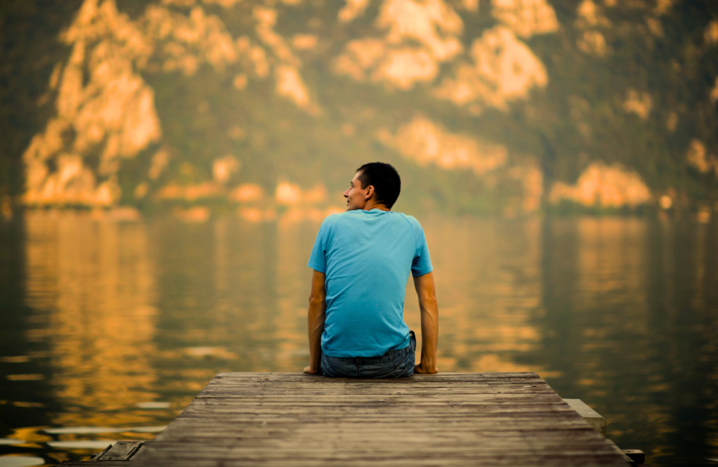 Man sitting on pontoon bridge, looking at the view. Hynosis sleep. Brisbane Livewell Clinic