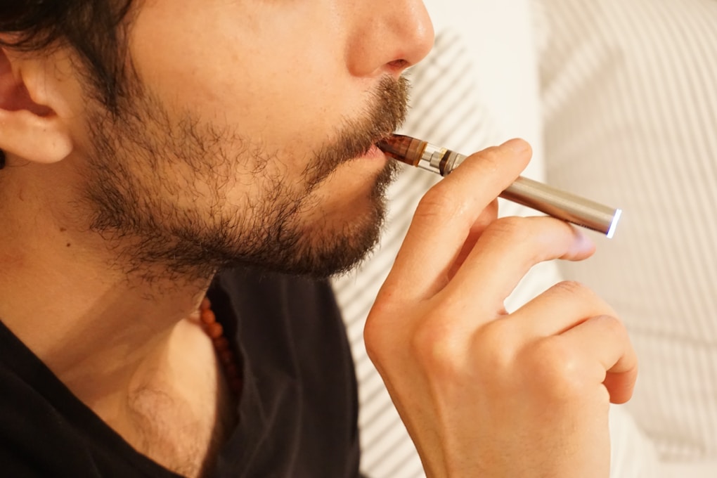 Man in black shirt smoking a vape. Hypnosis for Quit Smoking and Quit Vaping