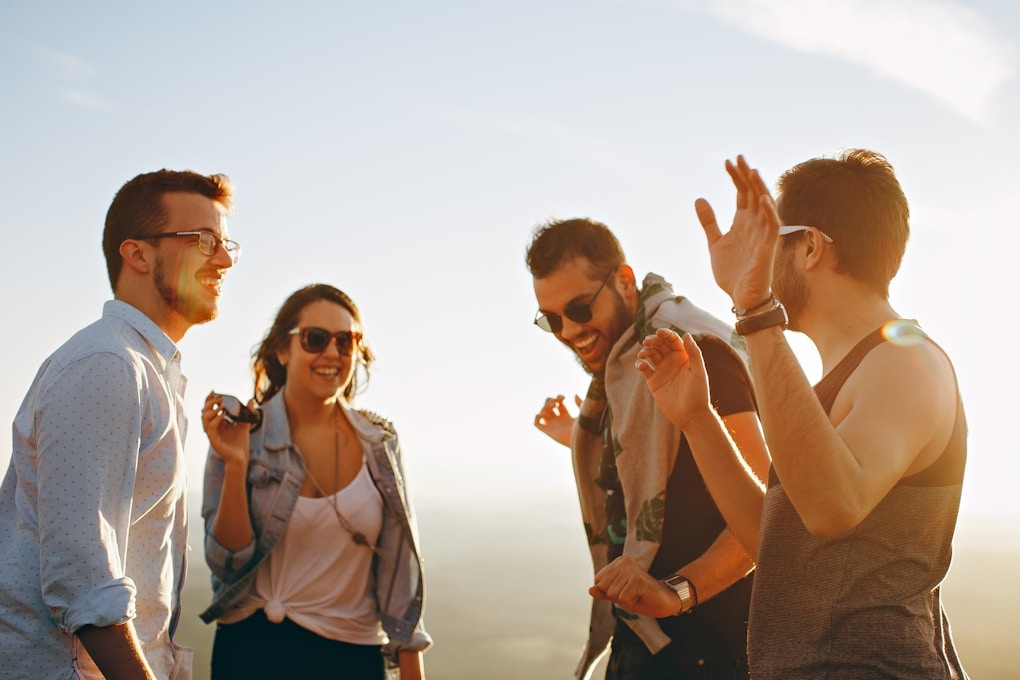 Three men and one woman laughing outside. Hypnosis for Smoking Cessation. Hypnosis to Quit Smoking and Vaping