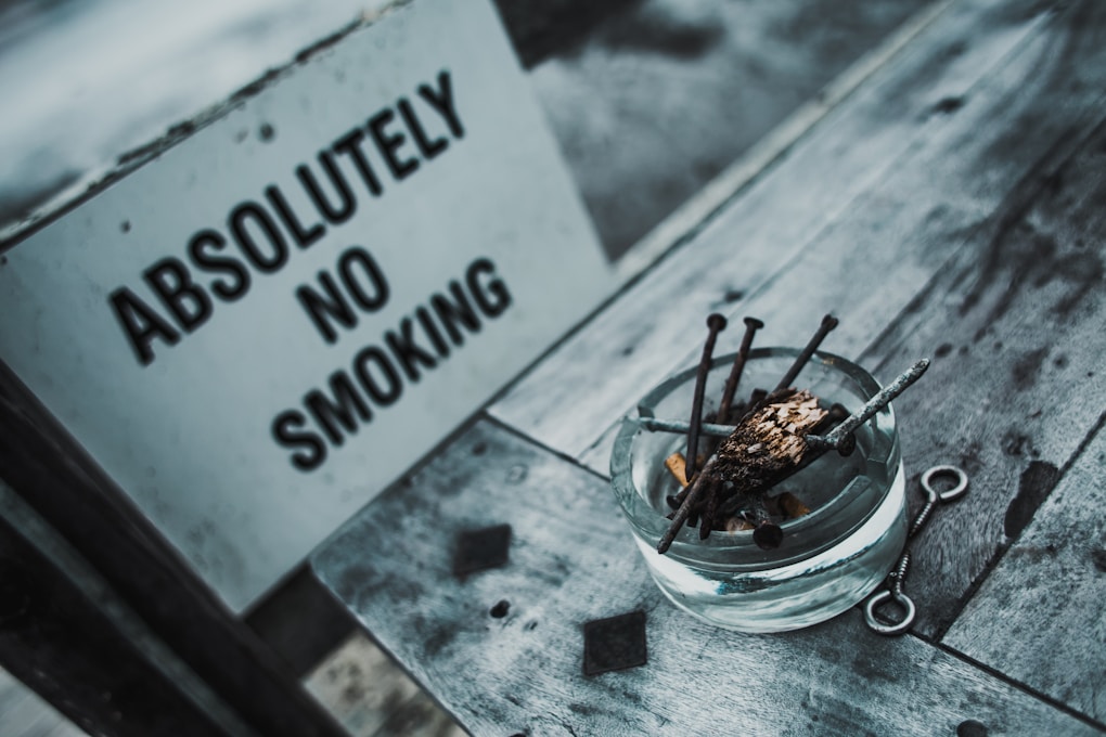 Clear glass ashtray with "Absolutely No Smoking" sign. Hypnosis for Smoking Cessation and Quitting Vaping