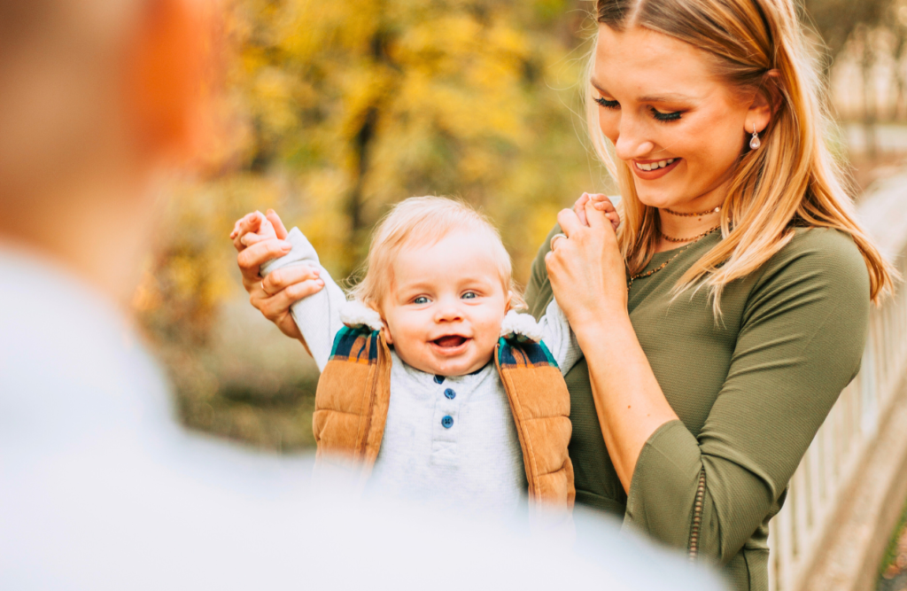 Mother holding her child while happily watching his father. Naturopath Cannon Hill. Brisbane Livewell Clinic